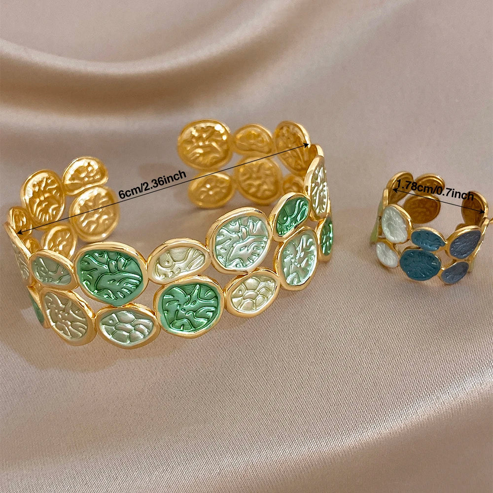 Gold-tone leaf coin cuff bracelet with green and blue enamel accents, open style