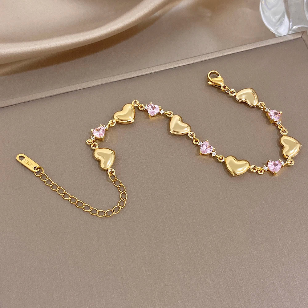 Gold-tone heart link bracelet set with pink crystal-like stones and lobster clasp