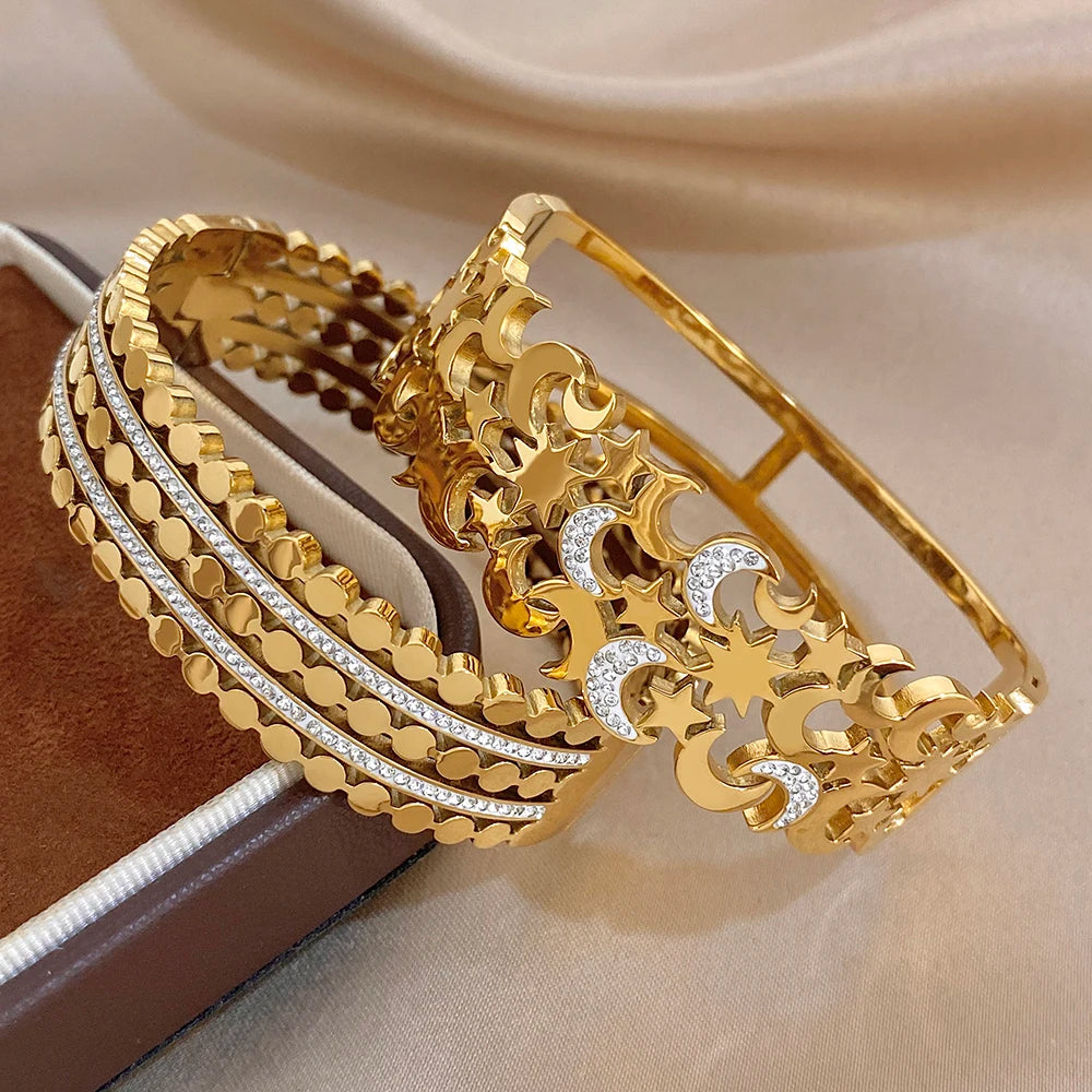 Gold-tone wide cuff bracelets with star and moon cutouts and clear rhinestone trim