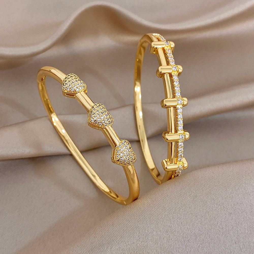 Pair of gold-tone zircon cuff bangles with rectangular bar link accents
