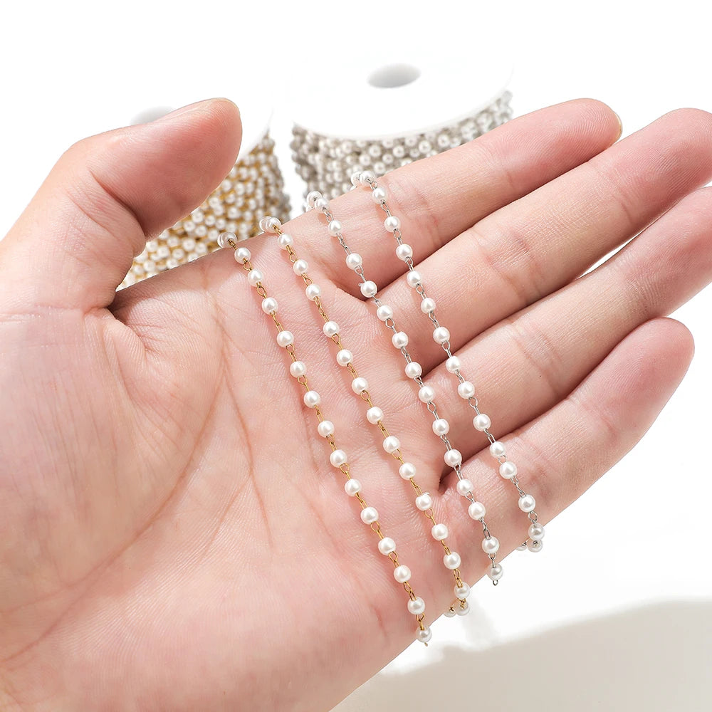 White imitation pearl bracelet chain on hand, gold-tone links with small round pearls
