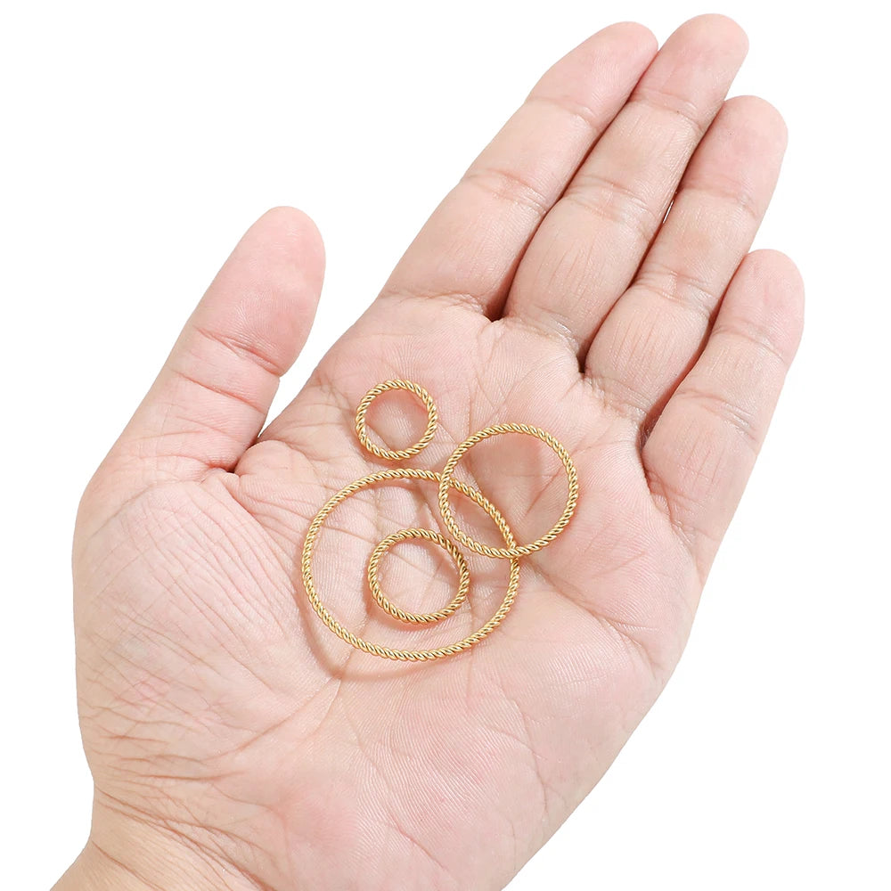 Gold spiral twisted round hoop ear wire connectors, small mixed sizes in hand