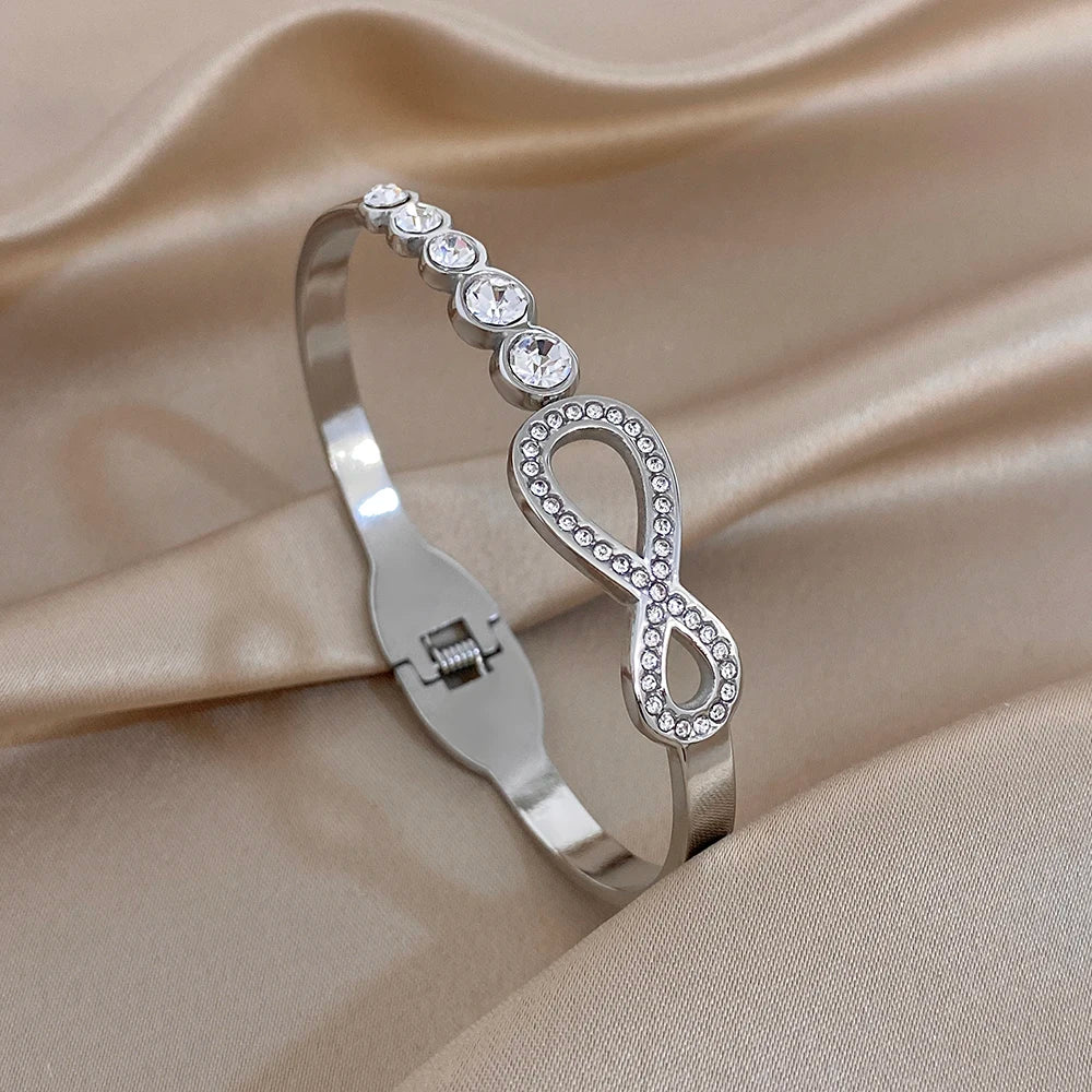 Silver-tone rhinestone infinity cuff bracelet with round crystal accents and hinge clasp