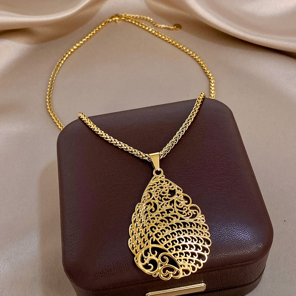 Gold-tone textured waterdrop pendant necklace with openwork floral cutouts
