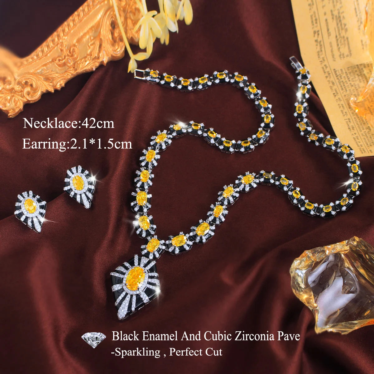 Necklace and earring set with yellow stones, black enamel, and a clear-stone pendant.