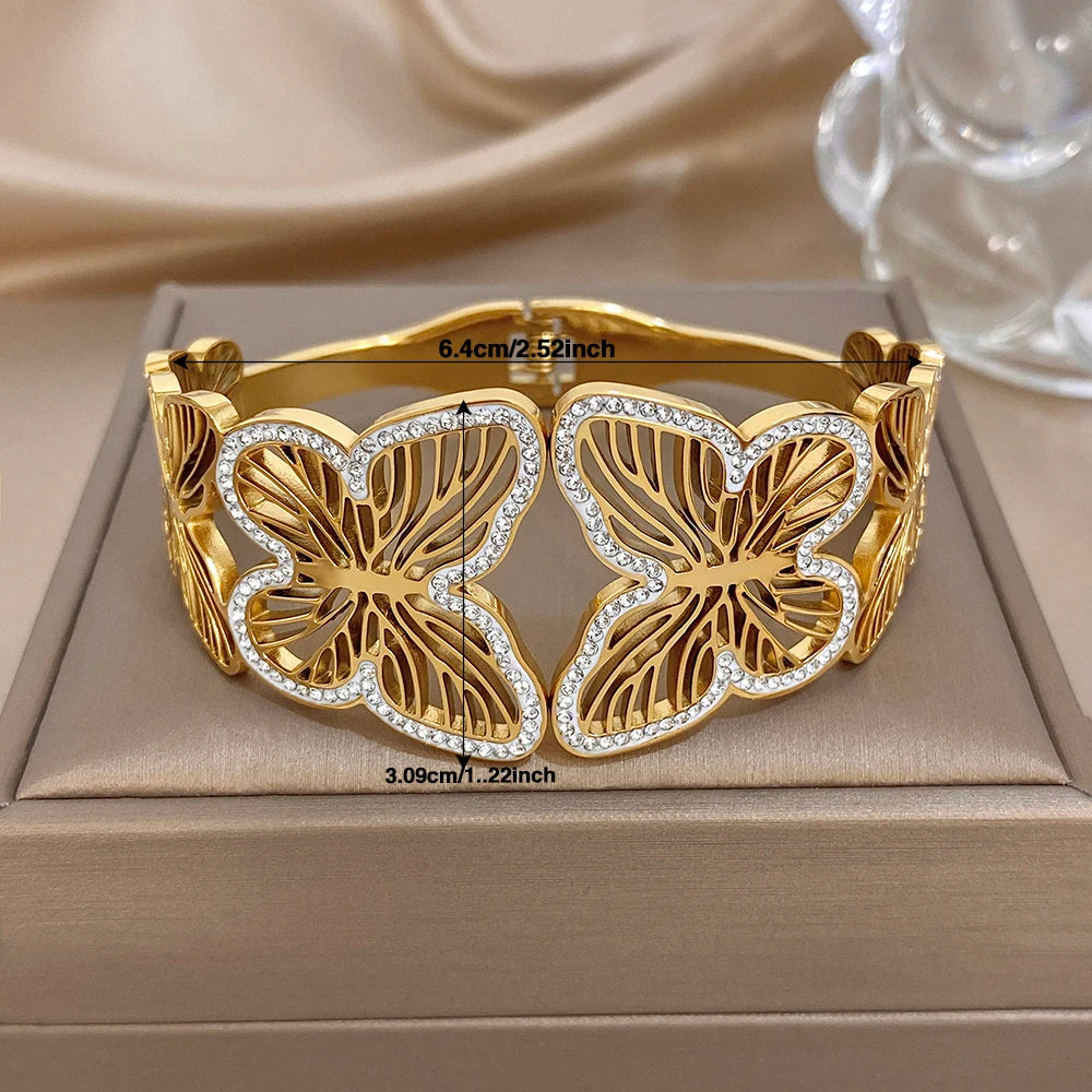 Gold-tone wide cuff bracelet with butterfly charms and rhinestone insets