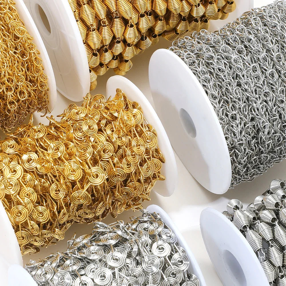 Assorted spiral chain on spools: gold, silver, and gray flower-like links
