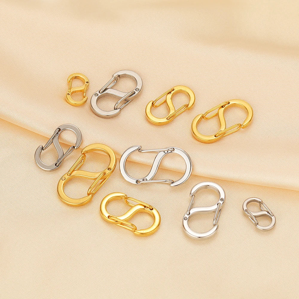 Gold and silver letter S spring lobster clasps on beige fabric, DIY connectors