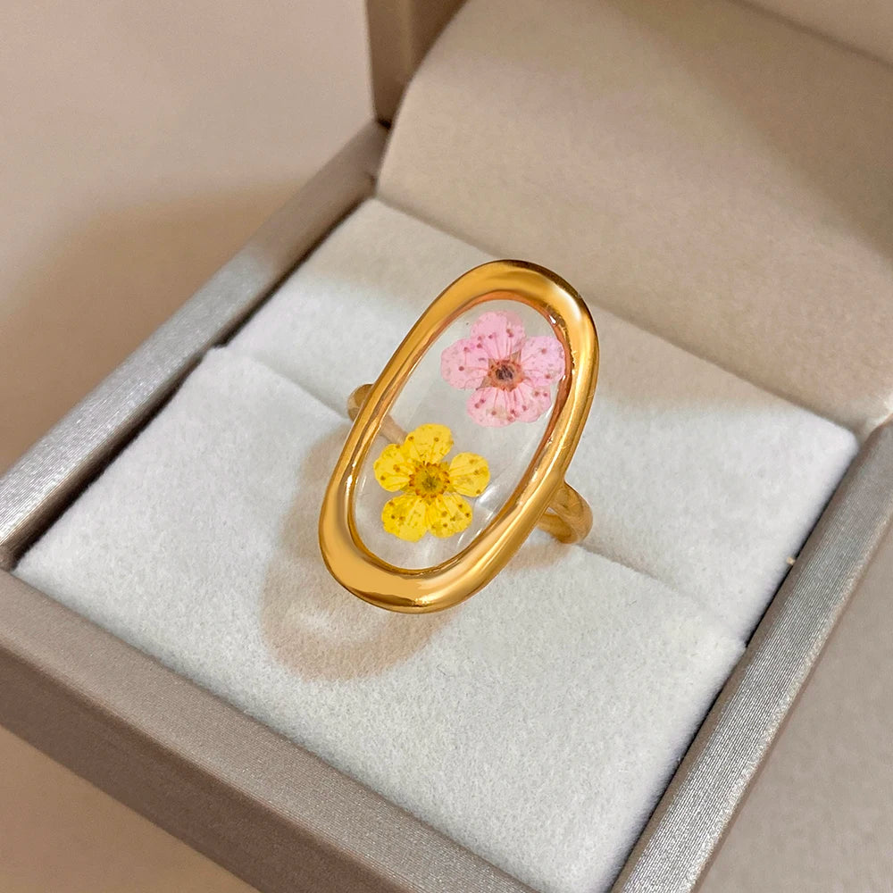 Gold-tone open oval ring in box, pink flower with yellow blossom