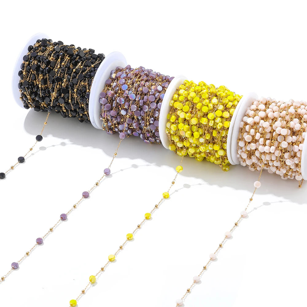Crystal bead chains on spools in black, purple, yellow, and white with gold links