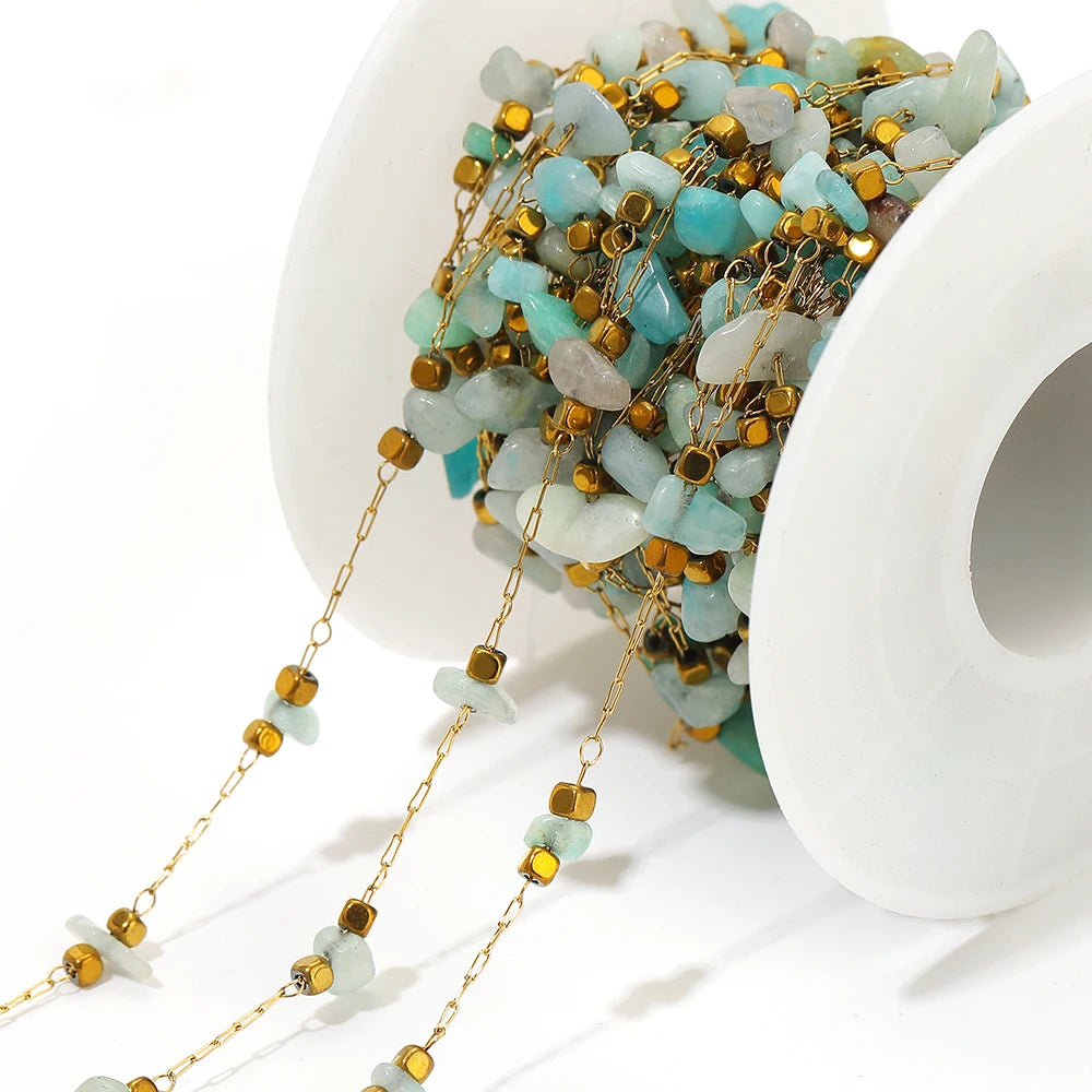 Close-up irregular glass bead link chain with light blue stones and gold-tone connectors