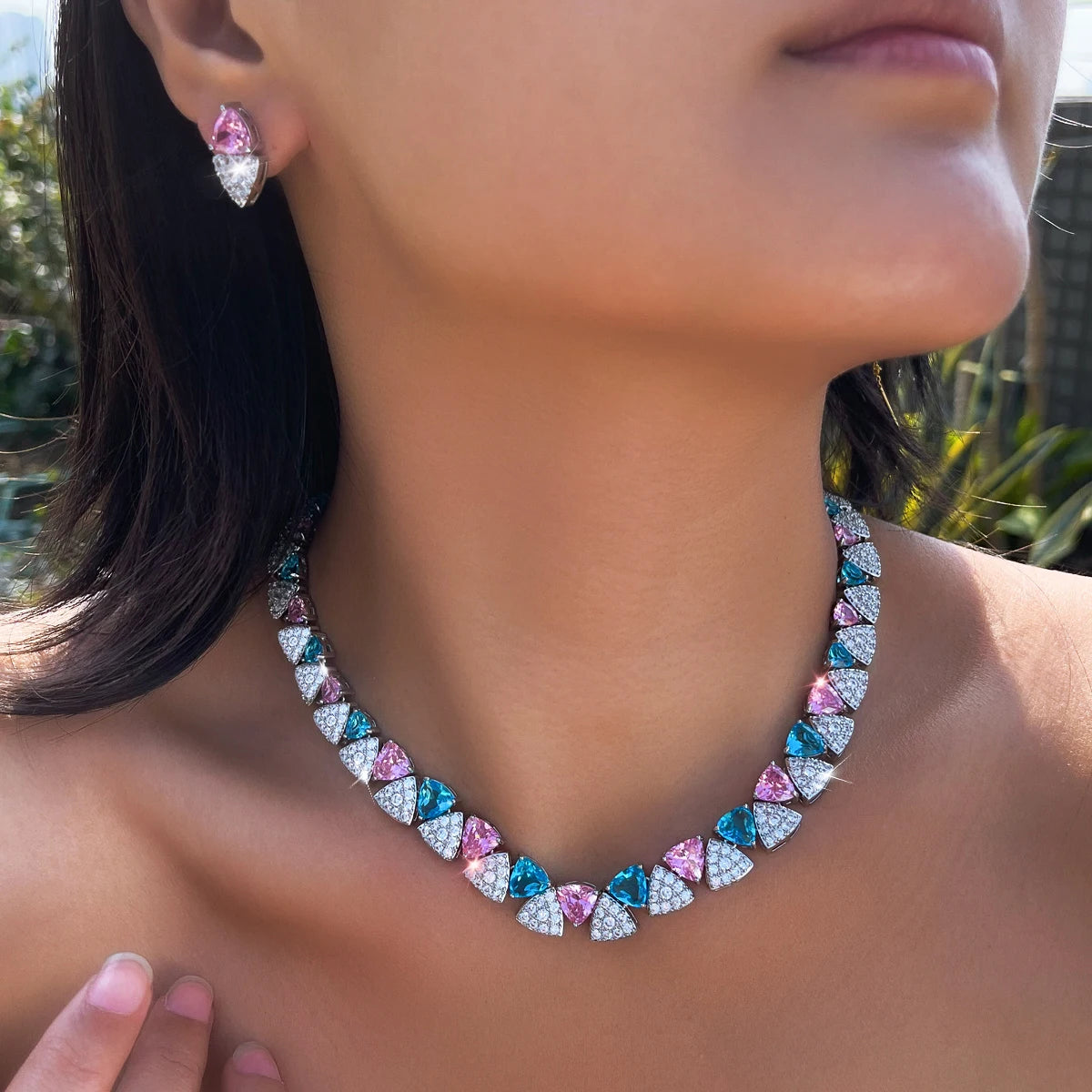 Blue, pink, and clear triangle stone necklace and matching drop earring worn