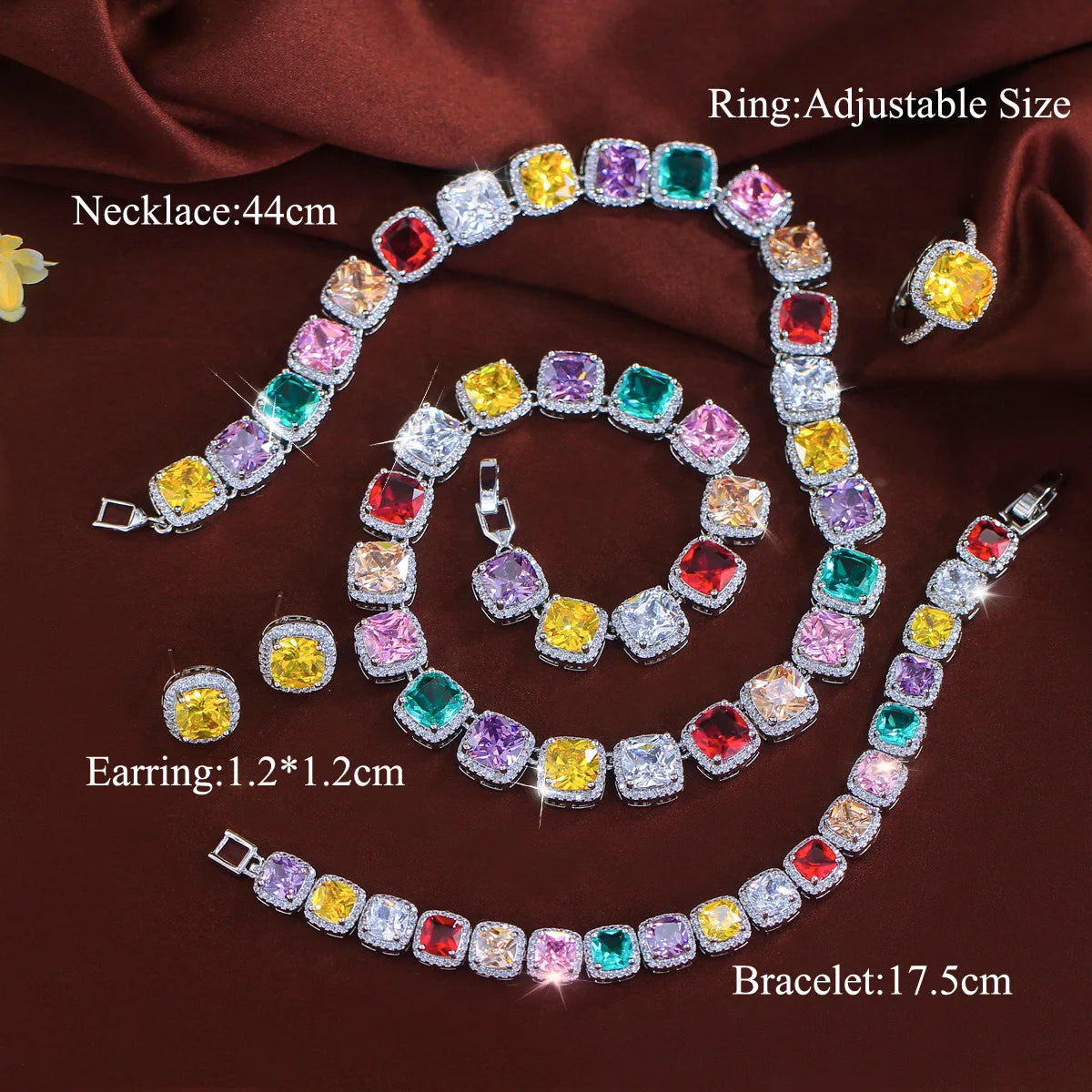 Multicolor CZ necklace, bracelet, and stud earrings set on dark background, silver-tone
