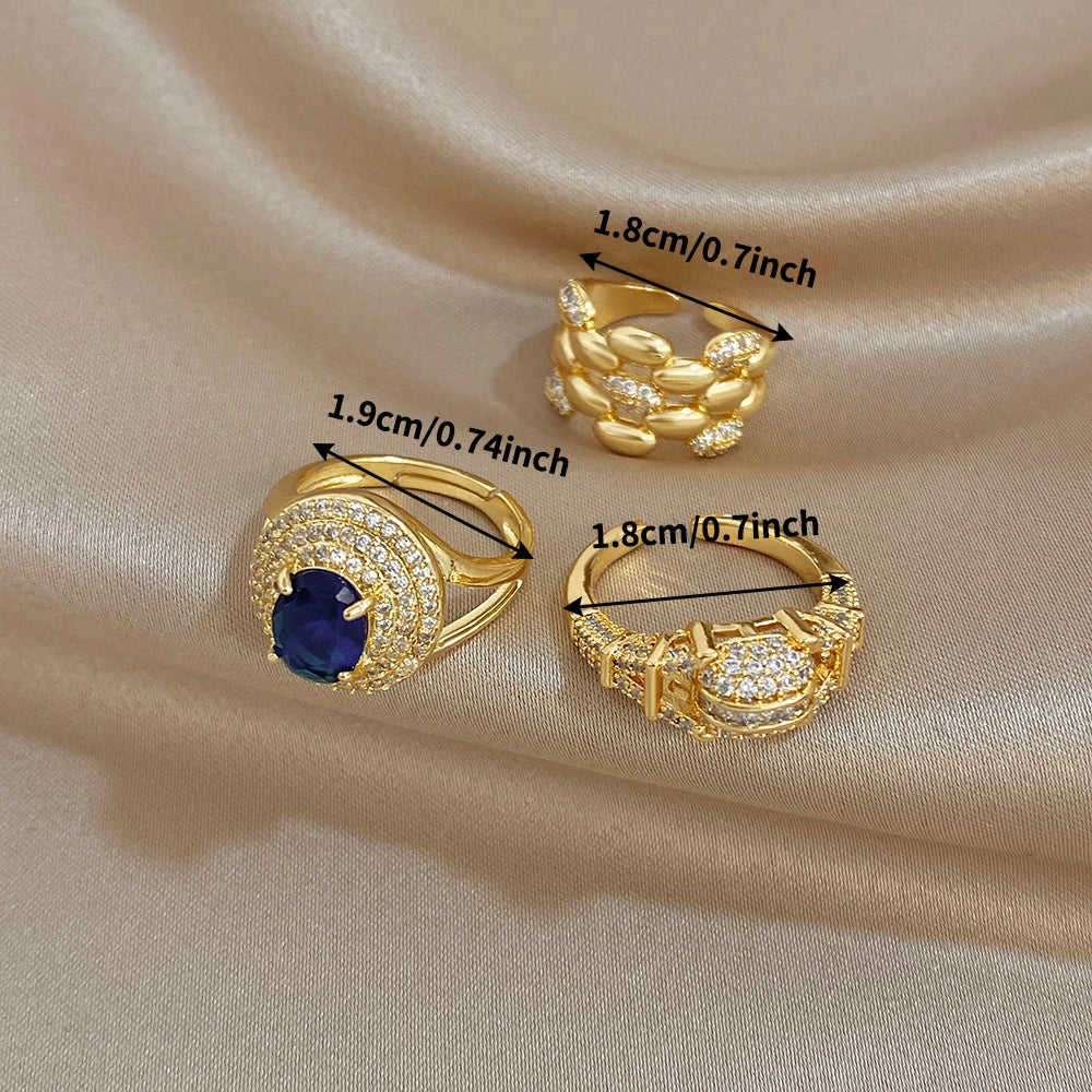 Gold-tone zircon open rings set, featuring a blue oval center ring and two clear crystal bands
