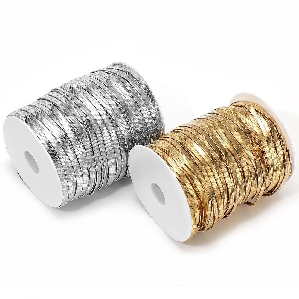 Reels of flat snake chain cords in silver and gold, ready for jewelry making