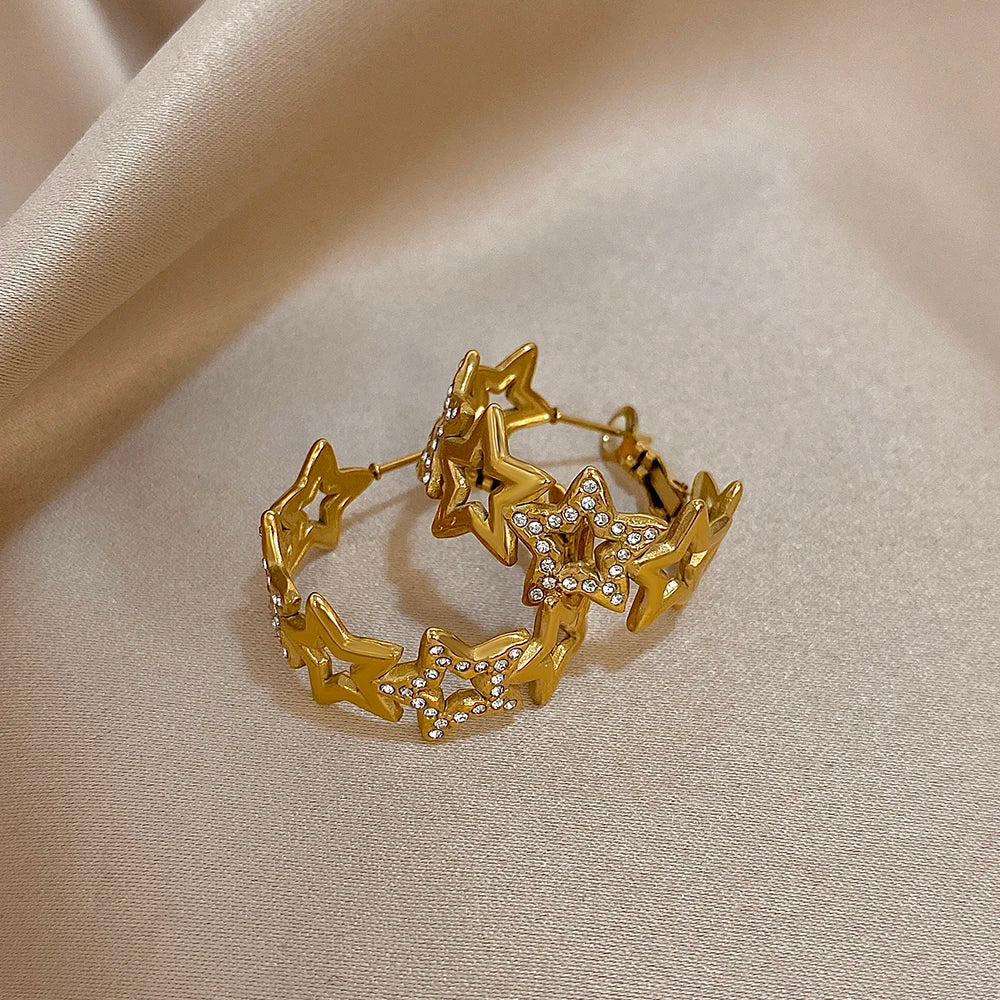 Gold-tone hoops linked by hollow star shapes and rhinestone-set stars
