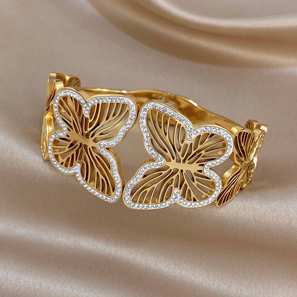 Gold-tone wide cuff bracelet with butterfly charms and rhinestone outlines