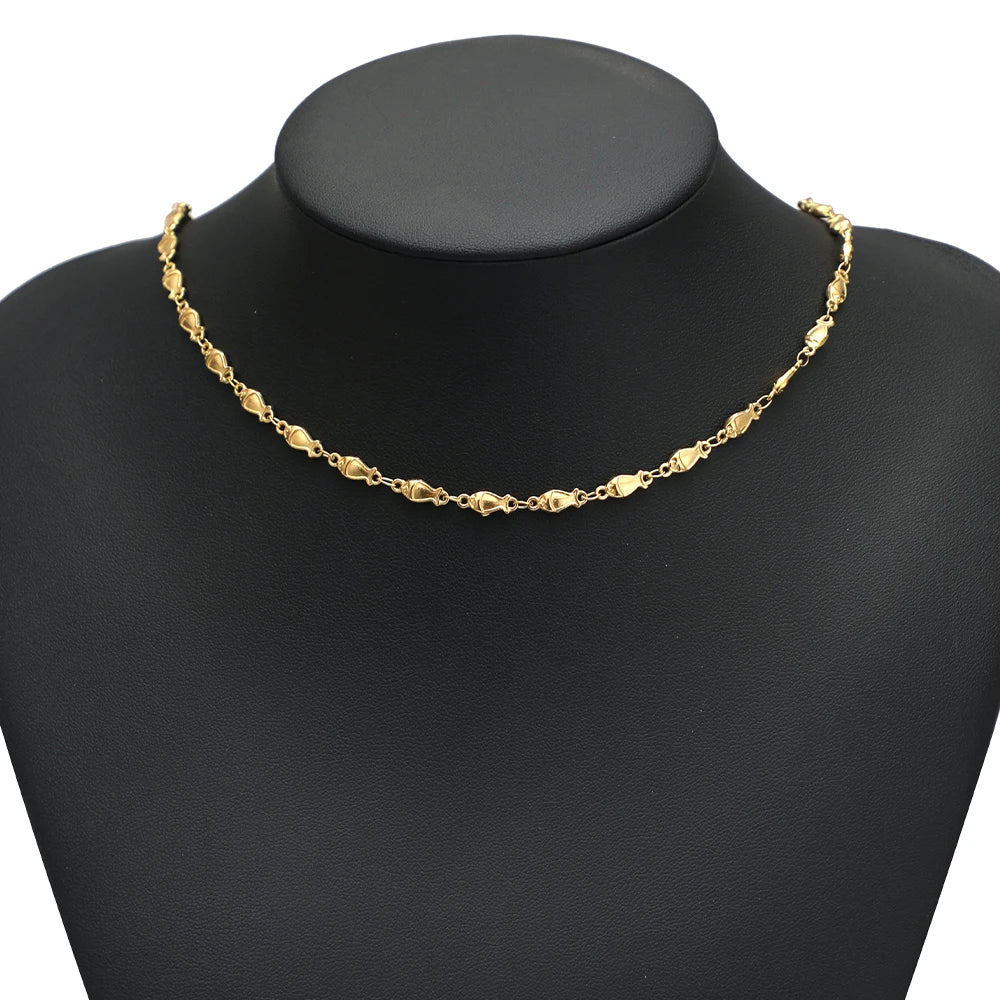 Gold sea-animal charm chain necklace on a mannequin bust