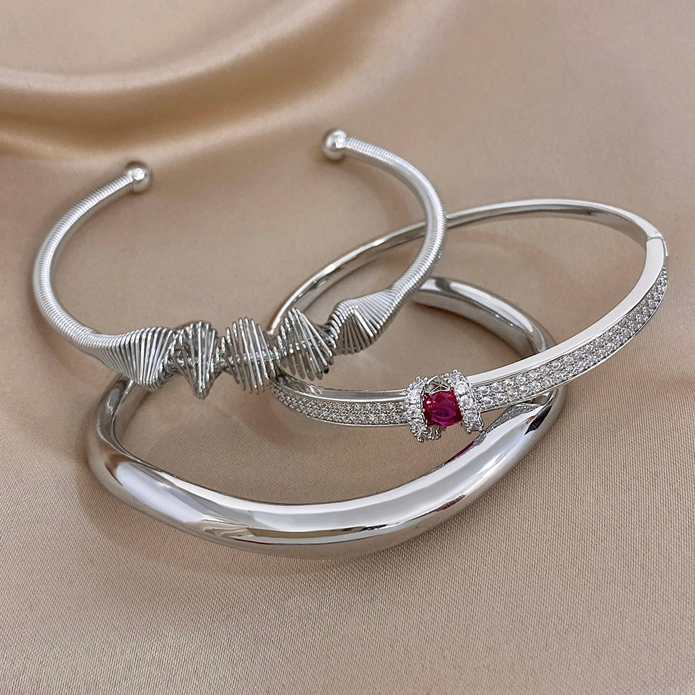 Silver cuff bangle set with textured wave band and crystal bar with red gemstone