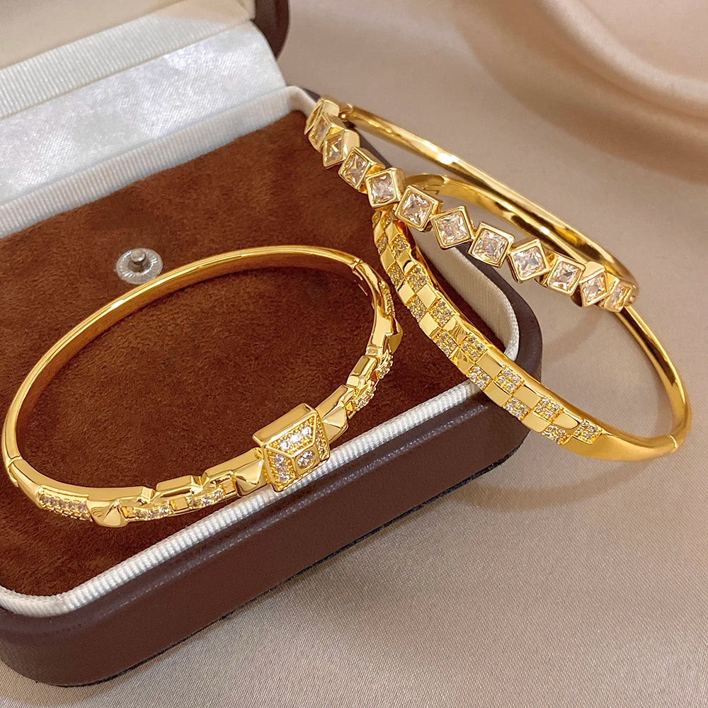 Gold-plated cuff bangle with square zirconia link row and geometric square centerpiece