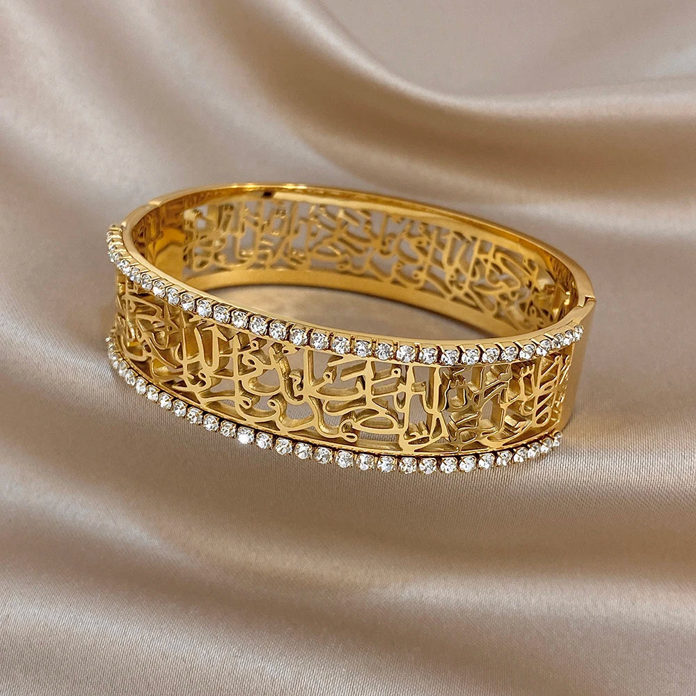 Gold-tone wide cuff bracelet with hollow pattern inlay and full rhinestone row