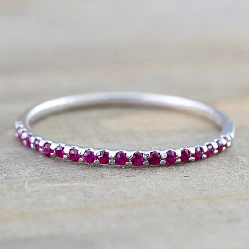Silver ring with row of maroon CZ stones along the band