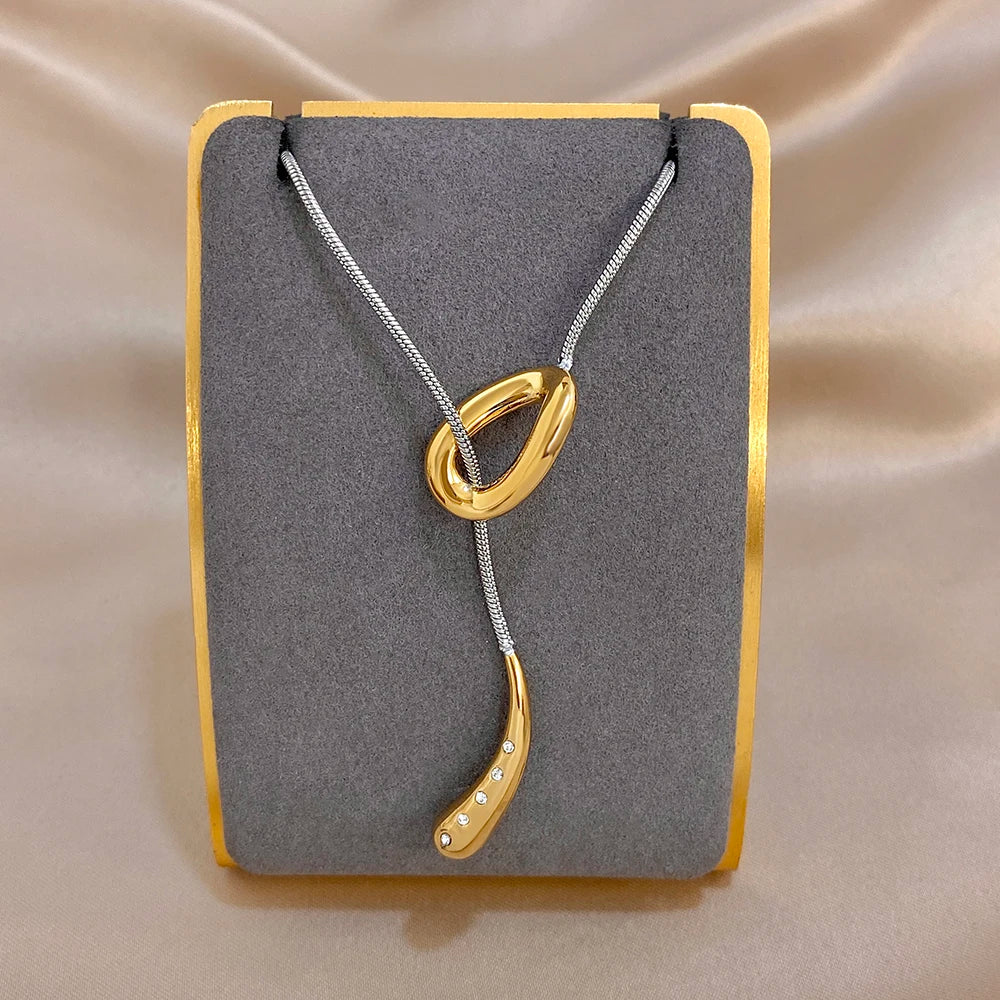 Silver snake chain necklace with gold knot pendant and waterdrop charm with rhinestones