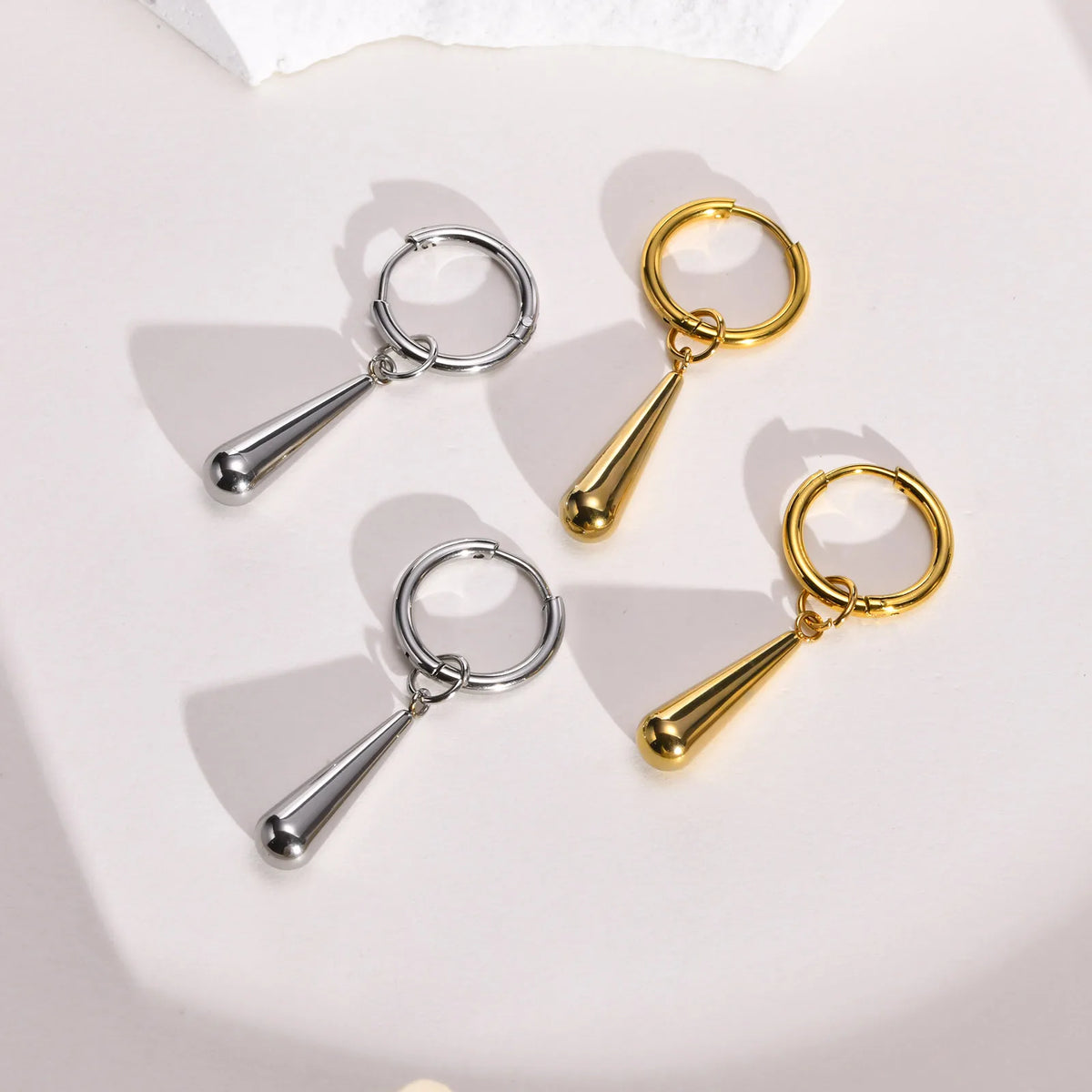 Gold- and silver-tone hoop earrings with polished tapered drop pendants
