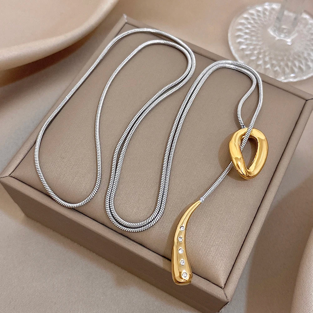 Silver snake chain necklace with gold knot pendant and waterdrop charm with rhinestones