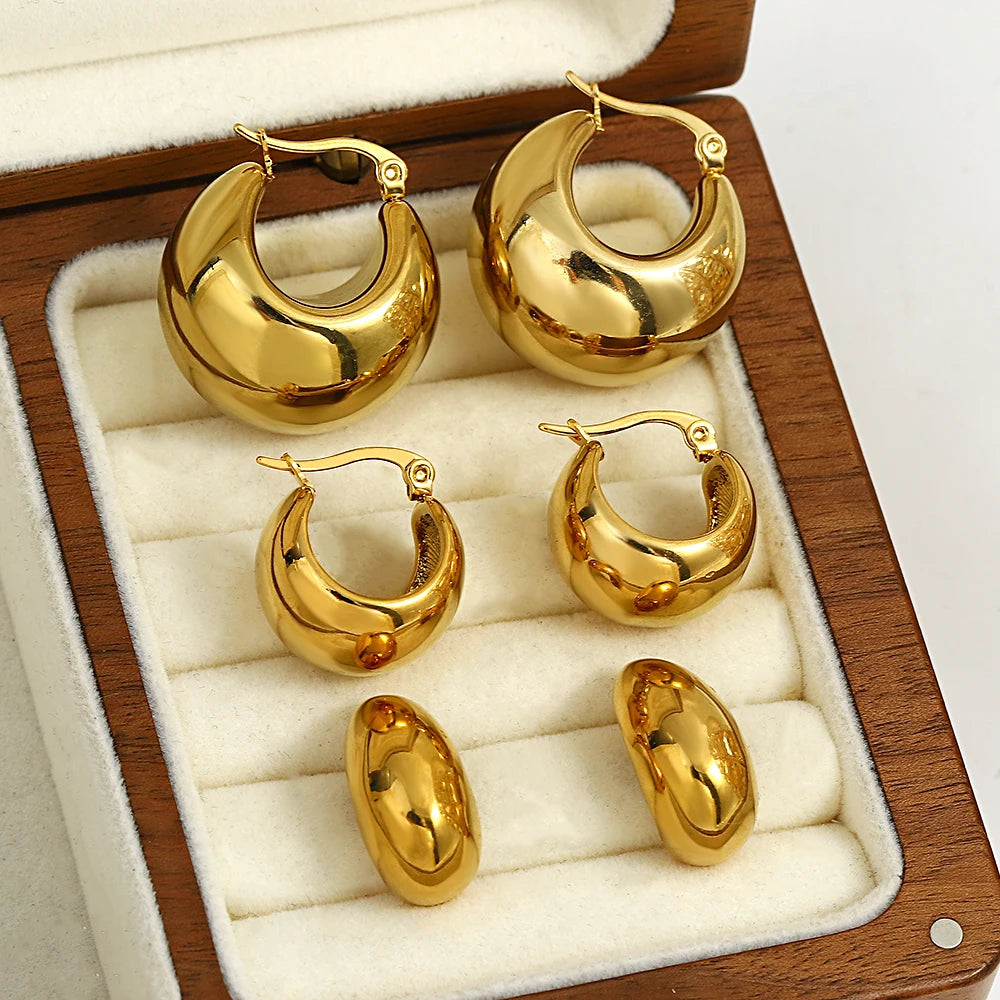 Gold-tone chunky hoop earrings in three sizes with rounded dome profiles
