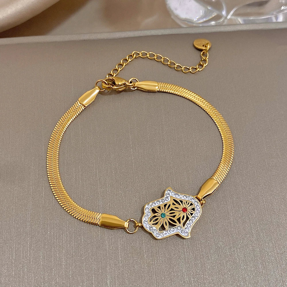 Gold-tone mesh bracelet with a crystal-edged hamsa filigree centerpiece