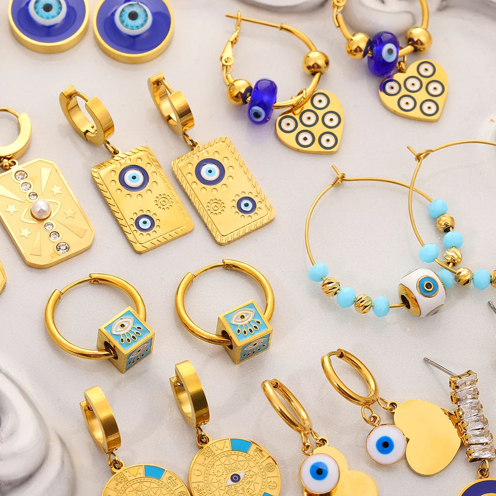 Gold-tone evil eye earrings in varied designs, including hoops and drops