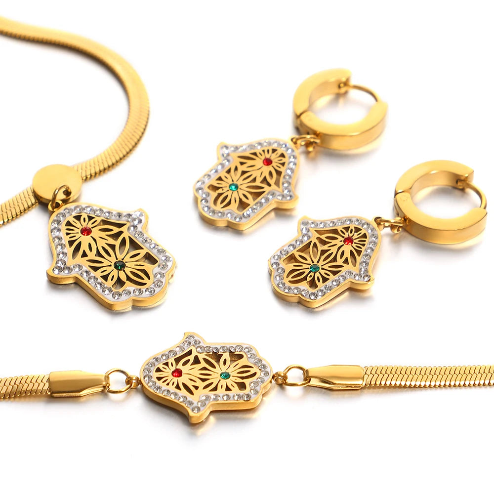 Close-up of gold-tone hamsa jewelry with floral filigree, crystal borders and colored accents