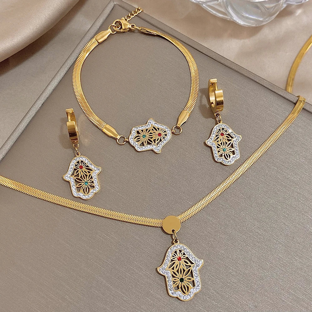 Gold-tone jewelry set with hamsa pendants, including a necklace, bracelet and hoop earrings