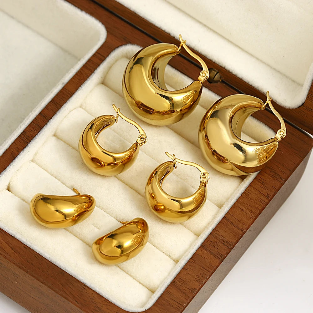 Gold-tone chunky dome hoops and matching oval stud earrings in a jewelry box