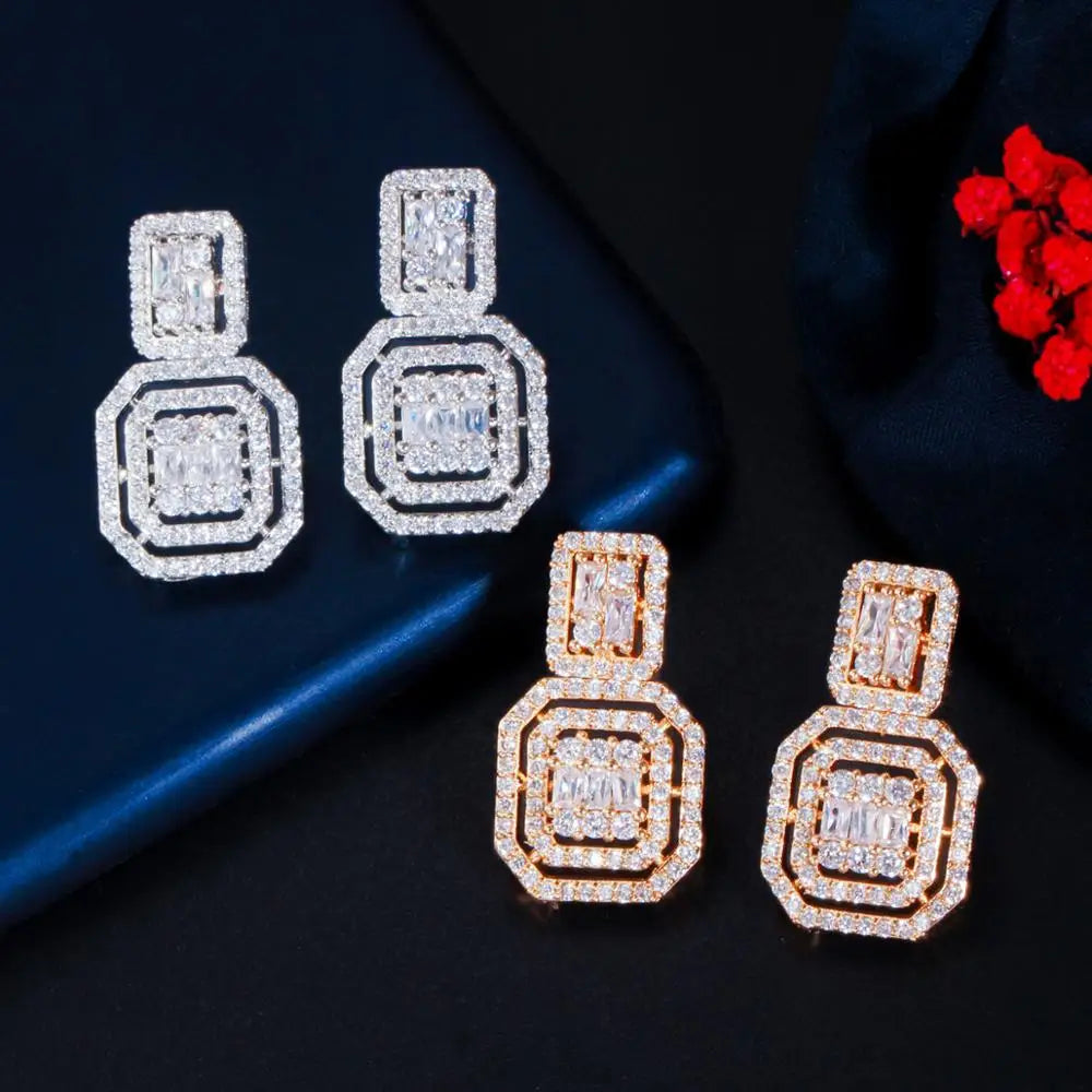 Square zirconia drop earrings in silver-tone and gold-tone, with layered geometric frames