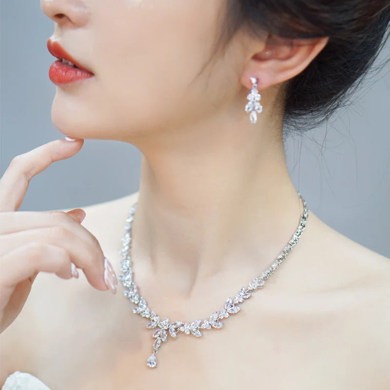 Silver leaf-drop cubic zirconia necklace and drop earrings on model, side view