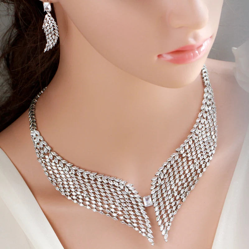 White zirconia feather necklace and dangling earrings modeled on a person