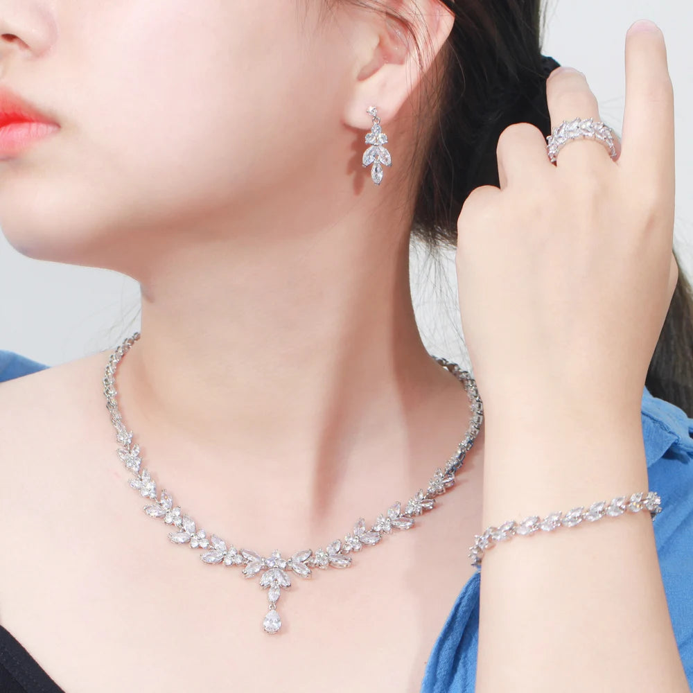 Woman wearing silver-tone cubic zirconia necklace and dangling earrings, ring visible