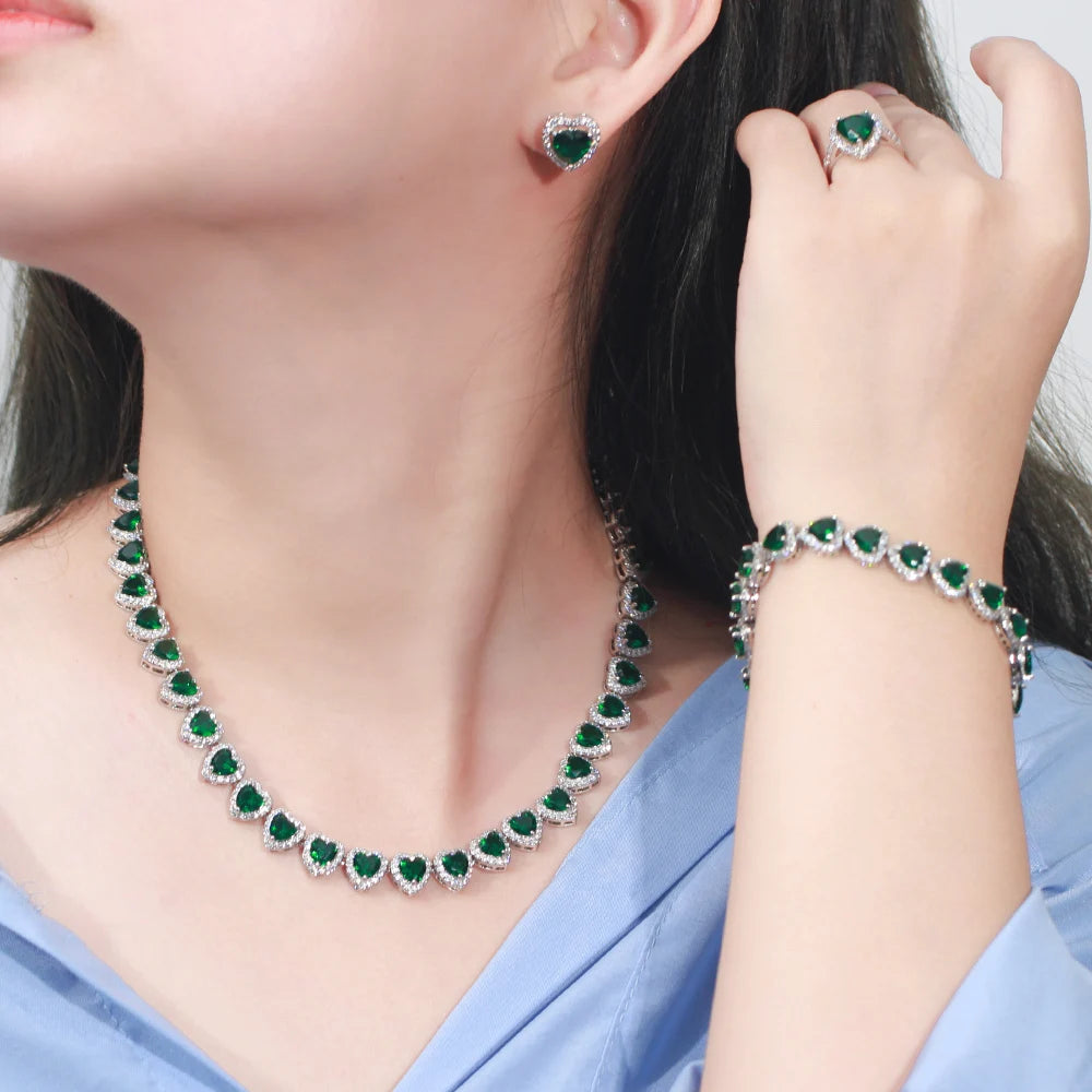 Green heart cubic zirconia bridal jewelry set on model: necklace, bracelet, earrings, ring
