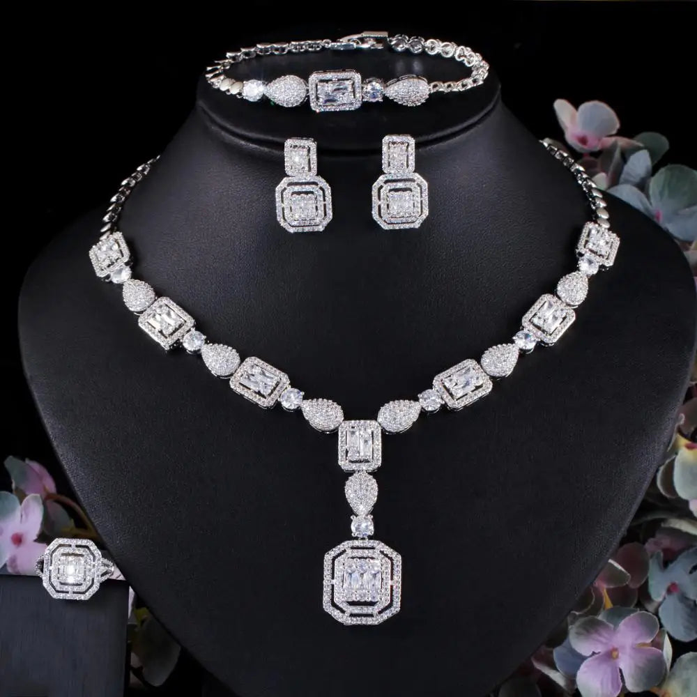 Silver-tone zirconia jewelry set featuring square-link necklace, bracelet, and stud earrings