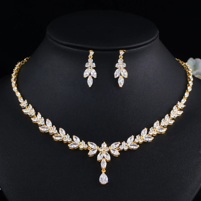 Gold leaf-drop cubic zirconia necklace and matching drop earrings on black bust