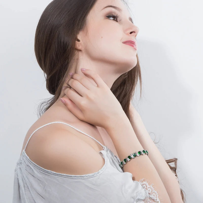 Green crystal leaf-accent tennis bracelet worn on the wrist