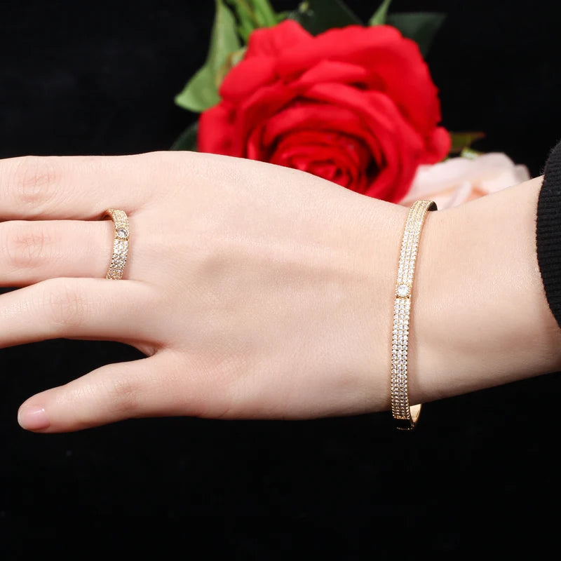 Silver-toned crystal bangle and ring set on hand with red rose background