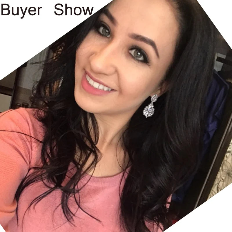 Silver-toned CZ drop earrings with oval halo clusters worn on the ear