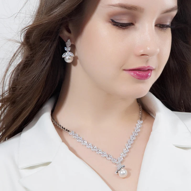 Crystal leaf necklace with pearl pendant and matching drop earring worn on a model