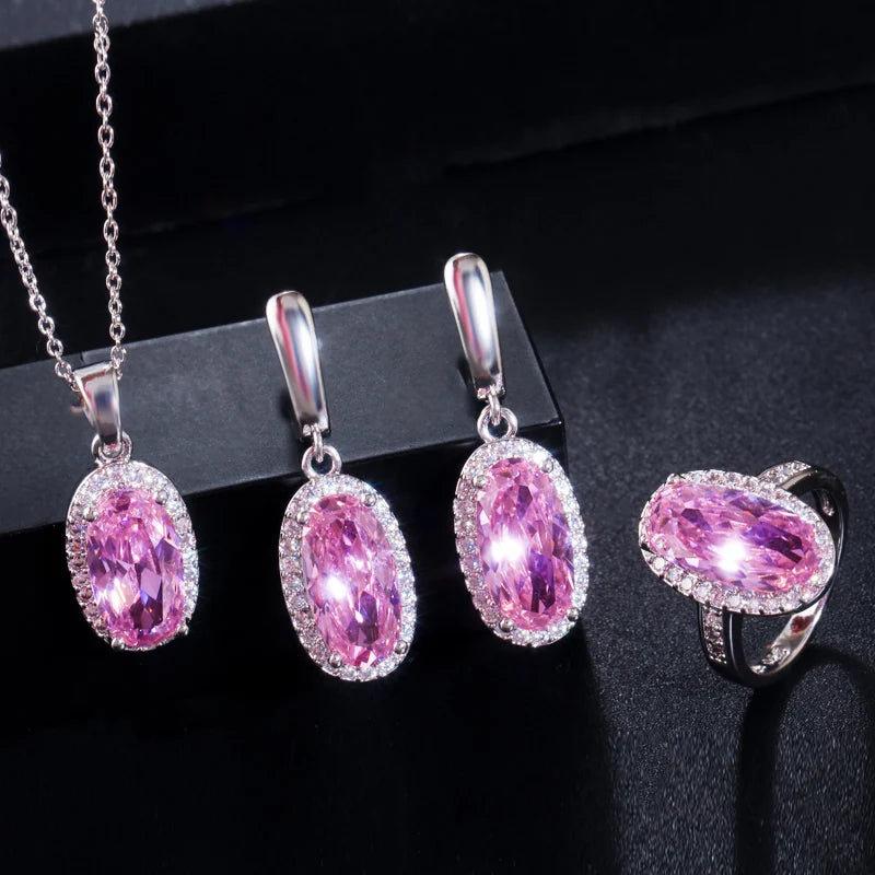 Oval pink CZ pendant necklace, drop earrings, and oval ring with silver-tone settings