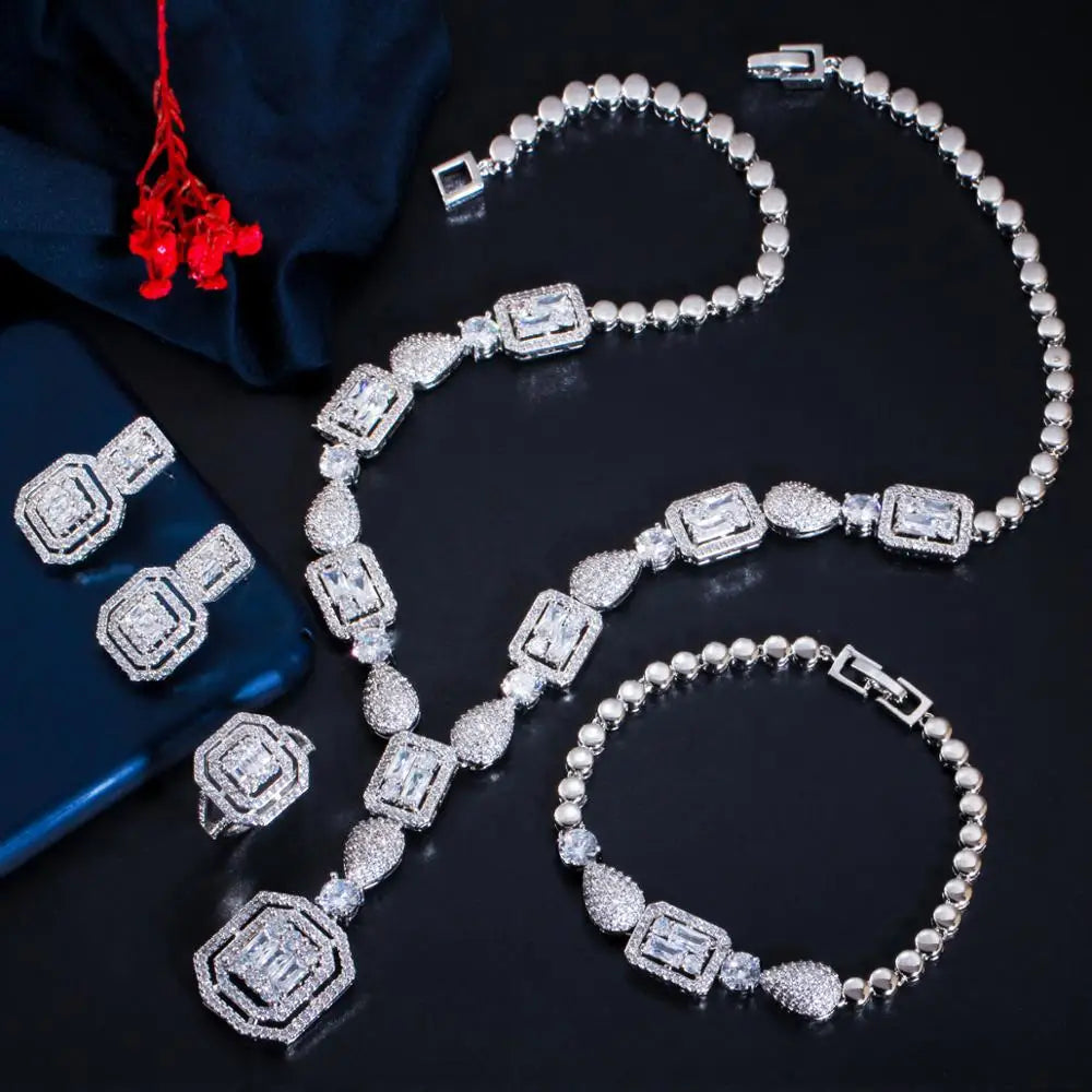 Silver-tone zirconia jewelry set with faceted square links, necklace, bracelet, and earrings