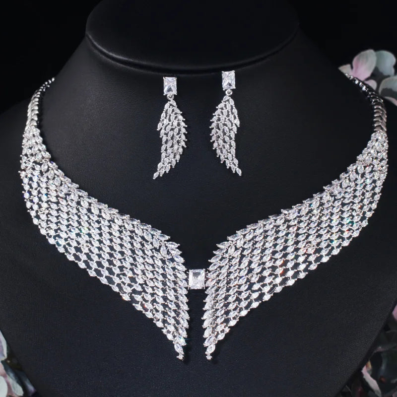 White zirconia feather necklace and matching dangling earrings displayed on a bust