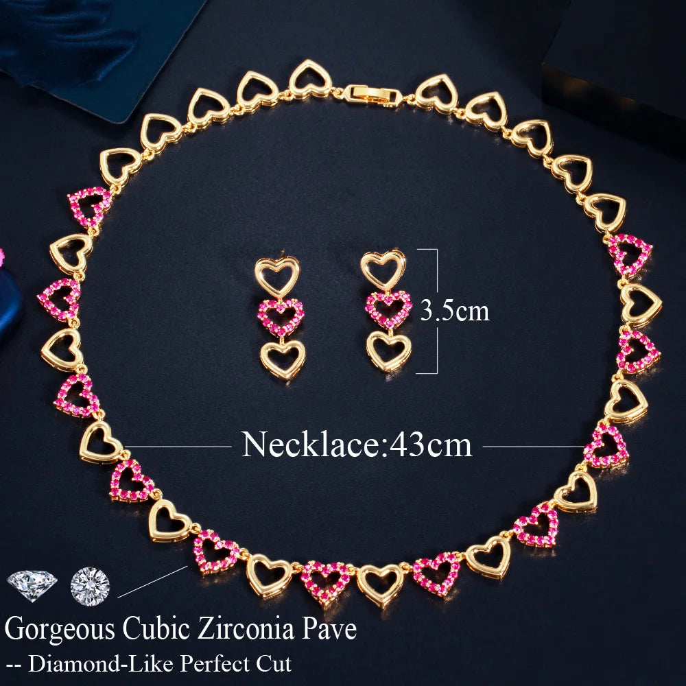 Gold-tone necklace and drop earrings with pink jeweled heart links